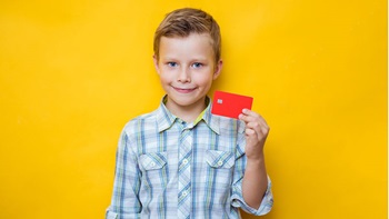 Jeune garçon tenant uyne carte de banque